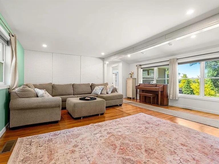Sun-filled family room with piano and antique rug