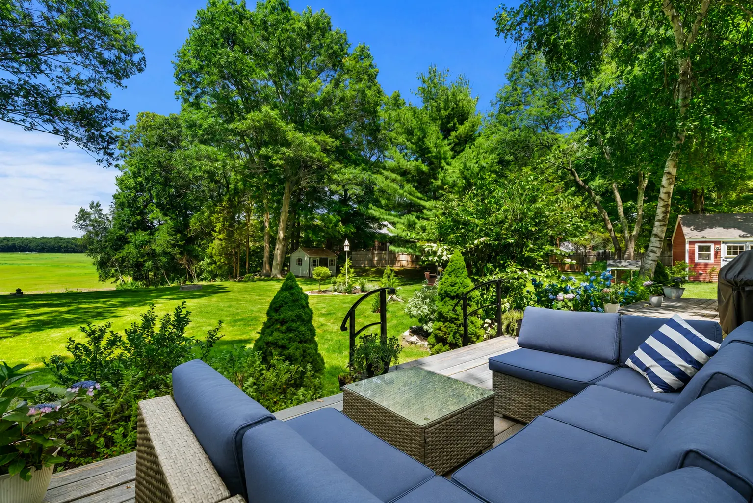 Deck seating overlooking the manicured lawn and open marsh at 10 Old Rowley Road